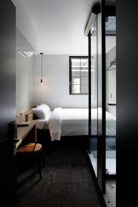 a bedroom with a bed and a desk and a window at HOTEL CEN in Tokyo