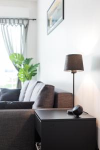 a living room with a couch and a table with a lamp at South West in Anglet