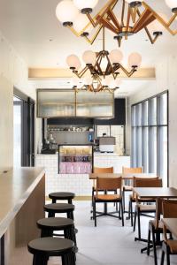 a restaurant with tables and chairs and a kitchen at HOTEL CEN in Tokyo