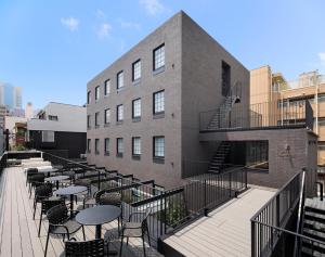 un patio con mesas y sillas frente a un edificio en HOTEL CEN en Tokio