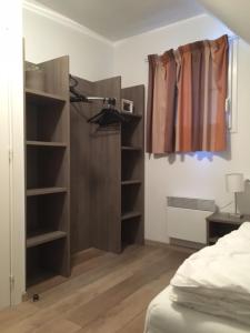 a bedroom with a closet with shelves and a bed at Equihen Plage Maison 83 in Équihen-Plage