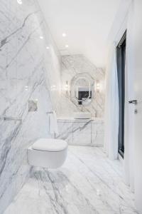 a white bathroom with a toilet and a mirror at Luxury Residence near Parlament in @YourVienna in Vienna