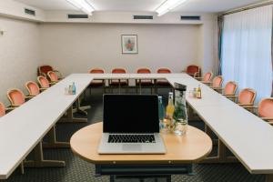 une salle de conférence avec un ordinateur portable sur une table dans l'établissement Landhaus Keller - Hotel & Restaurant, à Malterdingen