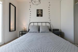 a bed in a bedroom with white walls at South West in Anglet
