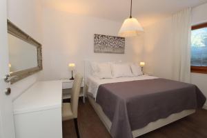 a bedroom with a bed and a desk and a mirror at Vila Nainer in Pag +125 photos