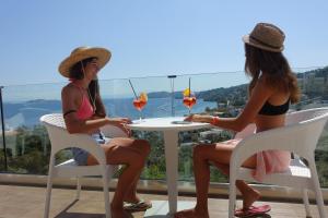 dos mujeres sentadas en una mesa con bebidas en Hotel Rene en Skíathos