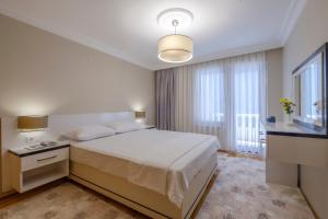 a bedroom with a white bed and a large window at Fethiye City Aparts in Fethiye