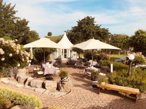 a patio with tables and chairs and umbrellas at Hotel Villa Seeschau - Adults only in Meersburg