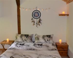 ein Schlafzimmer mit einem Bett mit Wolfkissen und Kerzen in der Unterkunft Les Divines Cascades in Roquefort-les-Cascades