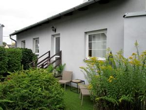 a white house with chairs and plants in the yard at Holiday House Smetánek in Bruntál