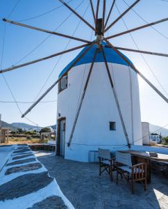 a windmill on top of a building with tables at Windmill Arades suite in Apollonia