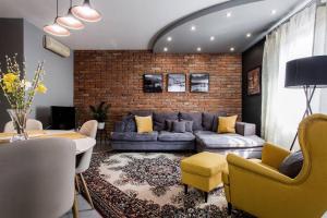 a living room with a couch and a brick wall at Luca Holiday House in Budaörs