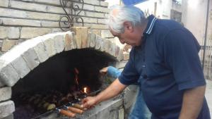 a man putting a fire in a brick oven at Lovely Goris in Goris
