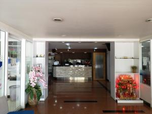 a lobby with flowers and a restaurant in the background at Sirapa Resident in Chachoengsao