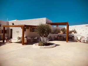 eine Terrasse mit einem Pavillon mit Tischen und Stühlen in der Unterkunft Aeris in Koufonisia