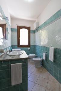 ドームス・デ・マリーアにあるHouse & Sea Chiaの緑のタイル張りのバスルーム(トイレ、シンク付)