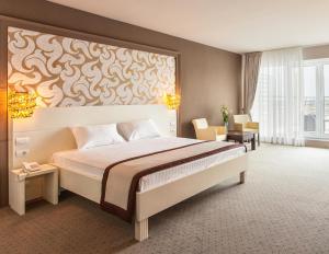 a bedroom with a large bed with a large painting on the wall at Continental Hotel in Odesa