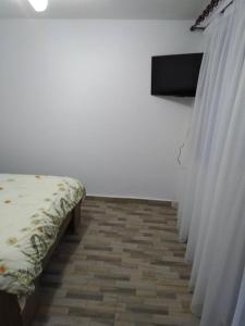 una habitación con una fila de camas y cortinas en Pensiunea Luminita, en Mustăţeşti