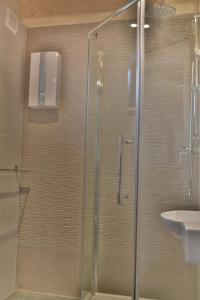 a bathroom with a shower and a sink at Domek - Apartament Marynarski z Kominkiem in Ustka