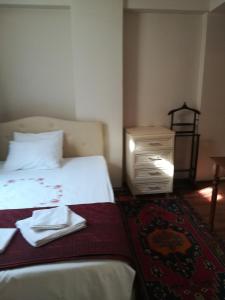 イスタンブールにあるイスタンブール アタマン スイーツのベッドルーム1室(ベッド1台、ドレッサー、皿付)