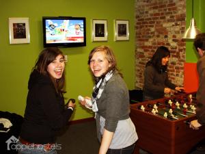 two women playing a video game with a chessboard at Apple Hostels of Philadelphia in Philadelphia