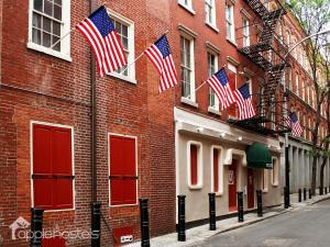 a red brick building with american flags on it at Apple Hostels of Philadelphia in Philadelphia