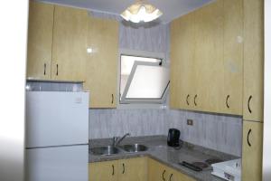 a kitchen with a white refrigerator and a sink at شقق ابراج شيراتون المنتزه in Alexandria