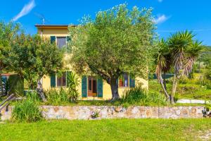 een geel huis met bomen ervoor bij Villino La Fontanella in Portoferraio