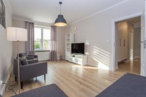 sala de estar con TV, sofá y silla en CR Apartament przy Rynku Sienkiewicza 6, en Białystok