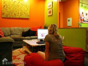 a woman sitting on a bean bag in front of a computer at Apple Hostels of Philadelphia in Philadelphia