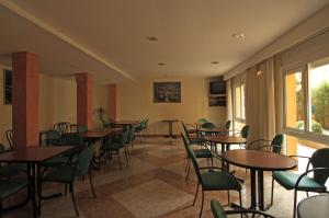 Habitación con mesas, sillas y ventana en Fonda Finet en Sant Felíu de Pallarols