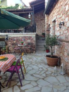 a patio with a table and chairs and a building at Proselinos in Dhimitsana