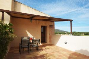 eine Terrasse mit einem Tisch und Stühlen auf einem Haus in der Unterkunft Finca Ses Cases Noves in Sant Llorenç des Cardassar