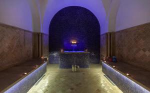 a hallway with a purple lighted room with a table at Dar El Jeld Hotel and Spa in Tunis