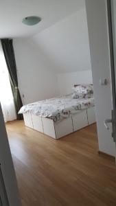 a small bedroom with a bed and a wooden floor at La Curtea Argeseana in Valea Iasului