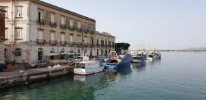 a group of boats docked in the water next to buildings at Casa Abela in Siracusa