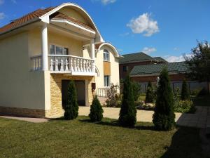 une maison avec un balcon au-dessus d'une cour dans l'établissement Дом с бассейном и сауной, à Boryspil