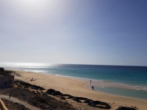 プラヤ・ハンディアにあるSuite del Mar 4 Jandiaの砂浜と海を歩く人々のいる浜