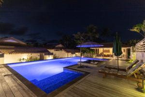 una piscina por la noche con sombrilla en Serenity Villas Rarotonga en Rarotonga