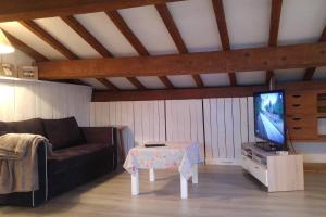 a living room with a couch and a table and a tv at Suite l'Escoundudo in Aix-en-Provence
