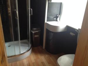 a bathroom with a shower and a sink and a toilet at Fairhaven Hotel on Woodfield Road in Blackpool