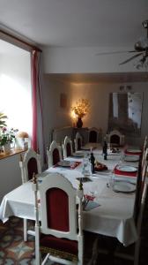 a dining room with a long table with white tables and chairs at Au Coeur de Rennes Chambres d'hôtes in Rennes-les-Bains
