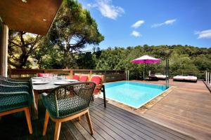 um deque com uma mesa e cadeiras ao lado de uma piscina em Villa Begur Hideaway con piscina privada em Begur