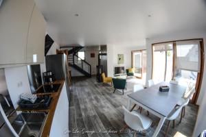 a kitchen and living room with a table and a dining room at Gîte Spa La grange in Kintzheim
