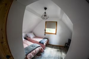 a attic room with two beds and a mirror at Gîte Spa La grange in Kintzheim