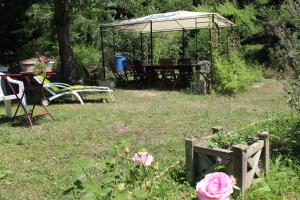 a garden with a picnic table and a gazebo at Au Coeur de Rennes Chambres d'hôtes in Rennes-les-Bains +9 photos