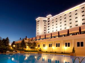 a hotel with a swimming pool at night at Ikbal Thermal Hotel & Spa Afyon in Afyon