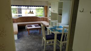 ein Wohnzimmer mit einem Sofa und einem Tisch in der Unterkunft DOMKI HOLENDERSKIE U Borysa in Pobierowo