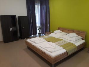 1 dormitorio con 1 cama grande y paredes verdes en Bella Vendégház Mórahalom en Mórahalom