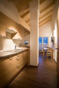 a kitchen with wooden cabinets and a dining room with a table at ff Appartements in Bramberg am Wildkogel